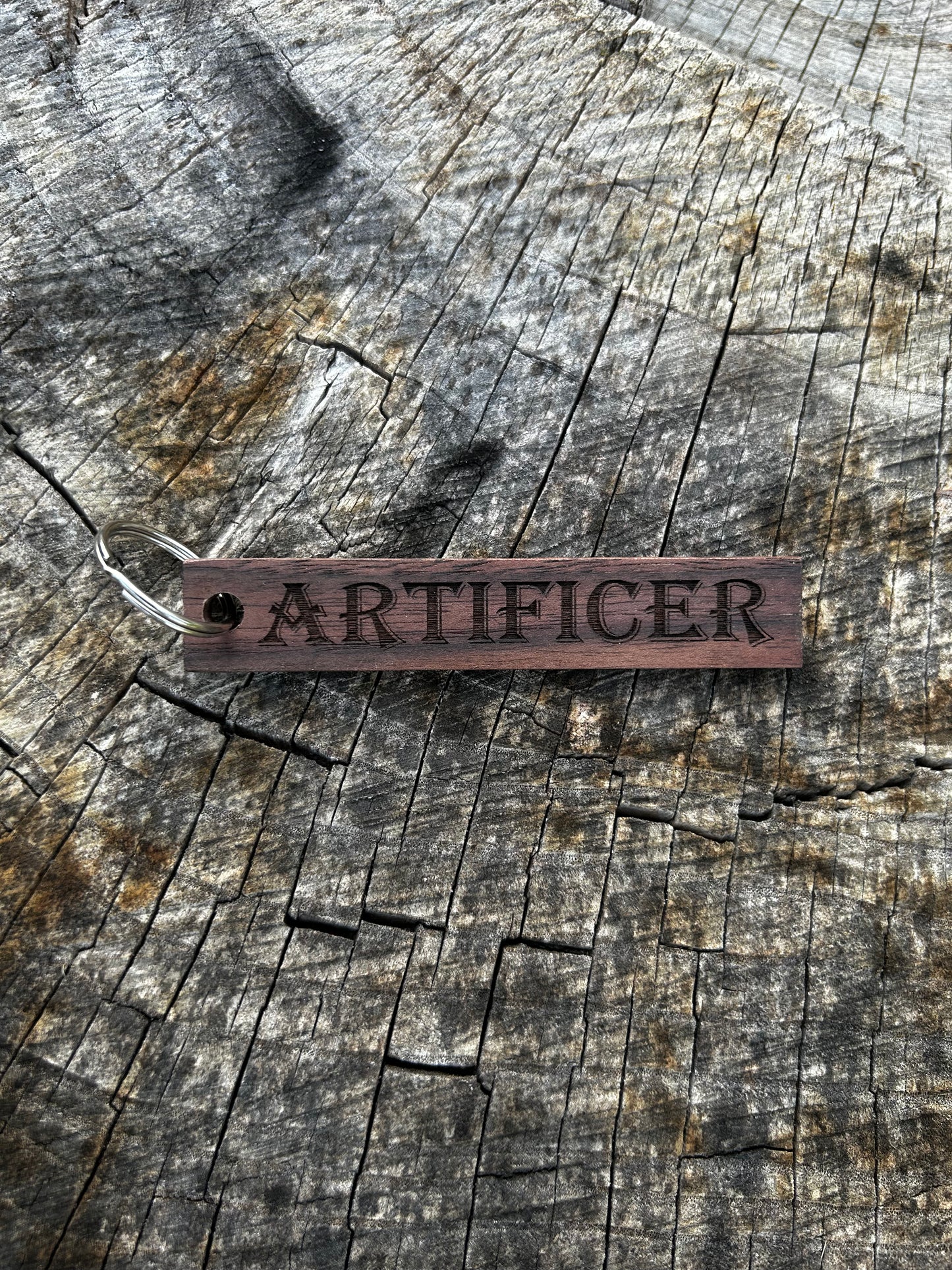 Walnut Wooden Keychain with the word "Artificer" and the Oakley Nerd Nook logo pressed into it