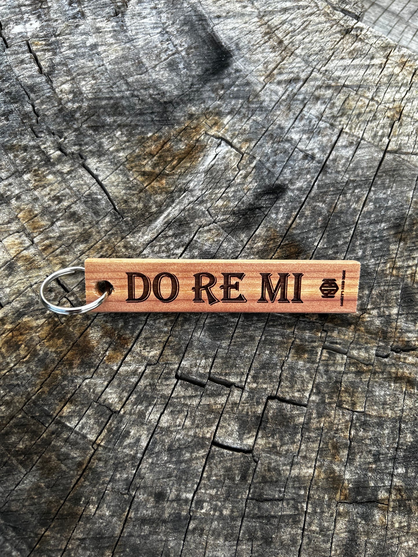 Cherry Wooden Keychain with the word "Do Re Mi" and the Oakley Nerd Nook logo pressed into it