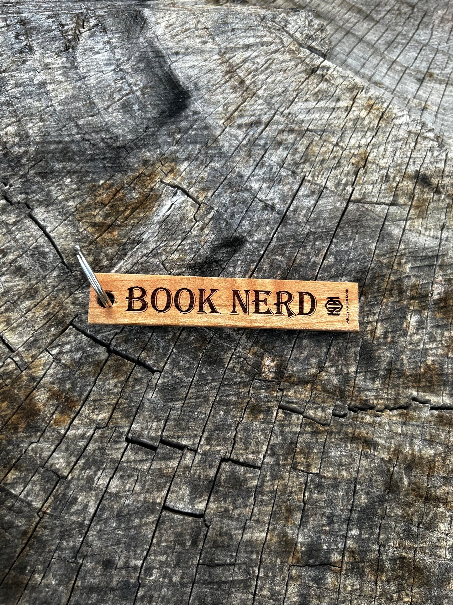 Mahogany Wooden Keychain with the word "Book Nerd" and the Oakley Nerd Nook logo pressed into it