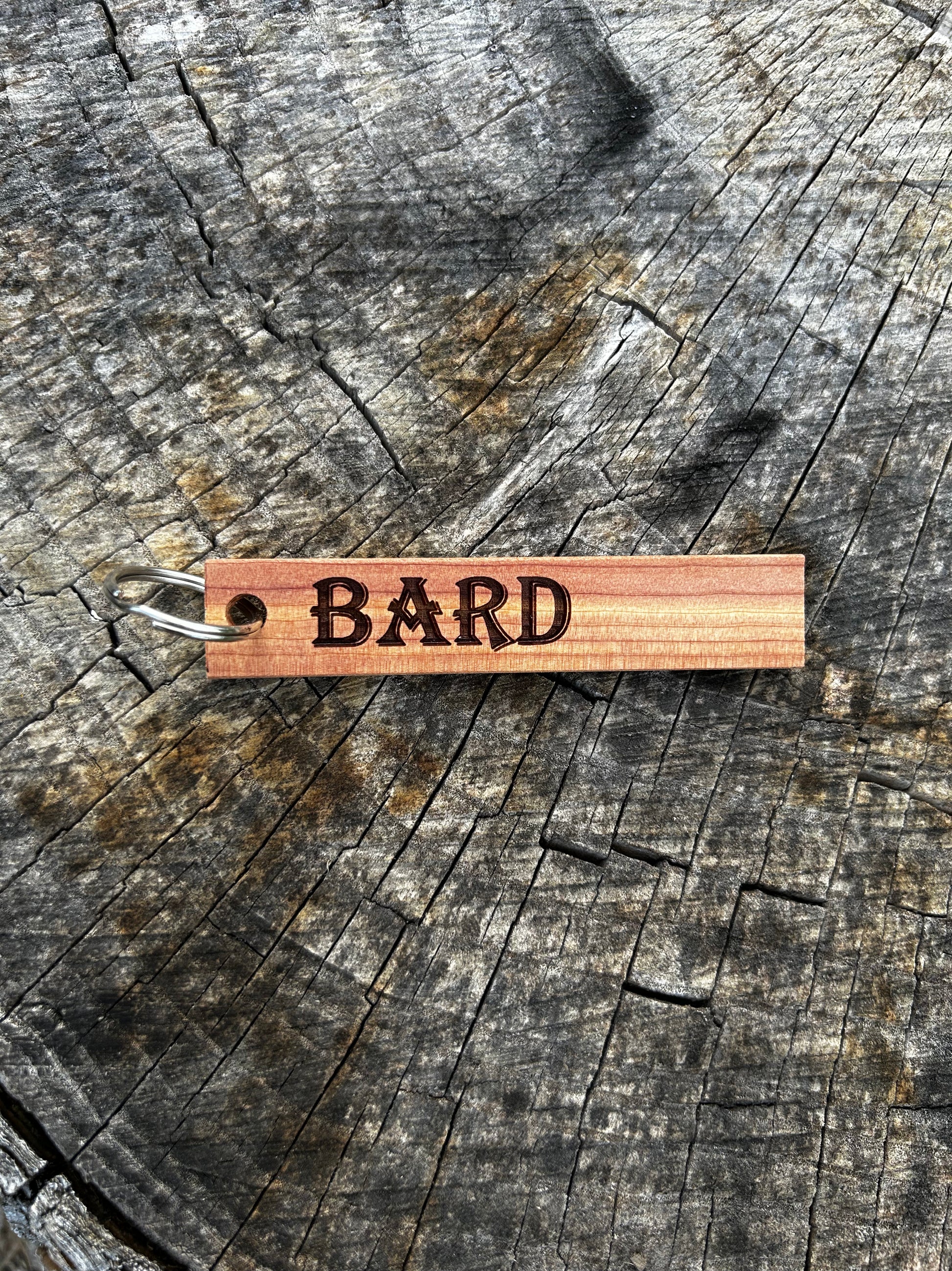 Oak Wooden Keychain with the word "Bard" and the Oakley Nerd Nook logo pressed into it