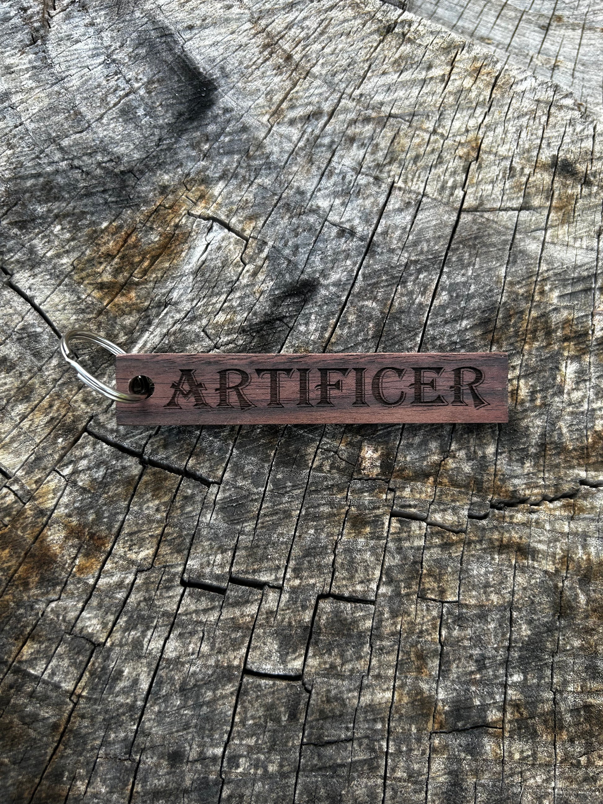 Walnut Wooden Keychain with the word "Artificer" and the Oakley Nerd Nook logo pressed into it