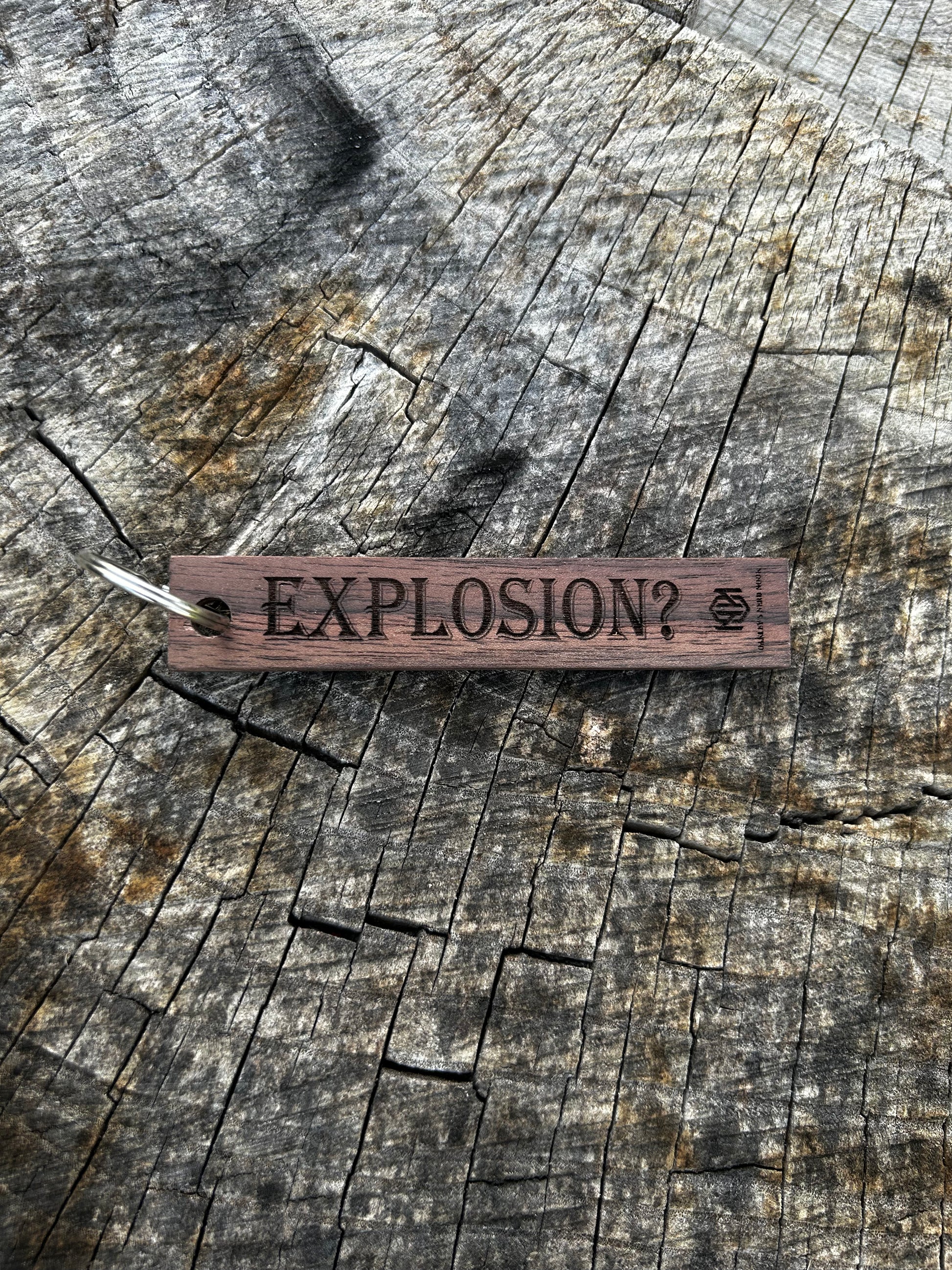 Walnut Wooden Keychain with the word "Explosion?" and the Oakley Nerd Nook logo pressed into it