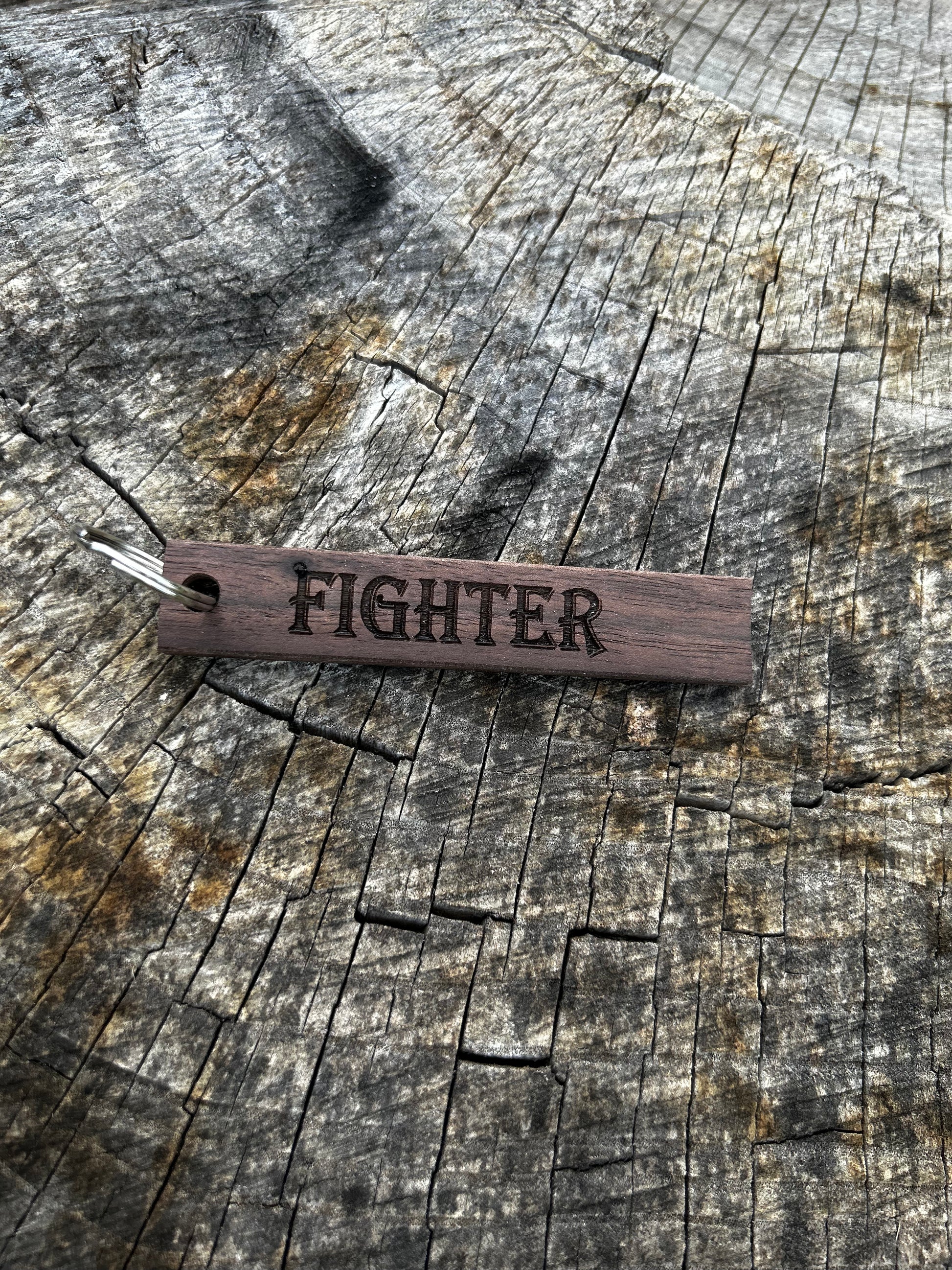 Willow Wooden Keychain with the word "Fighter" and the Oakley Nerd Nook logo pressed into it