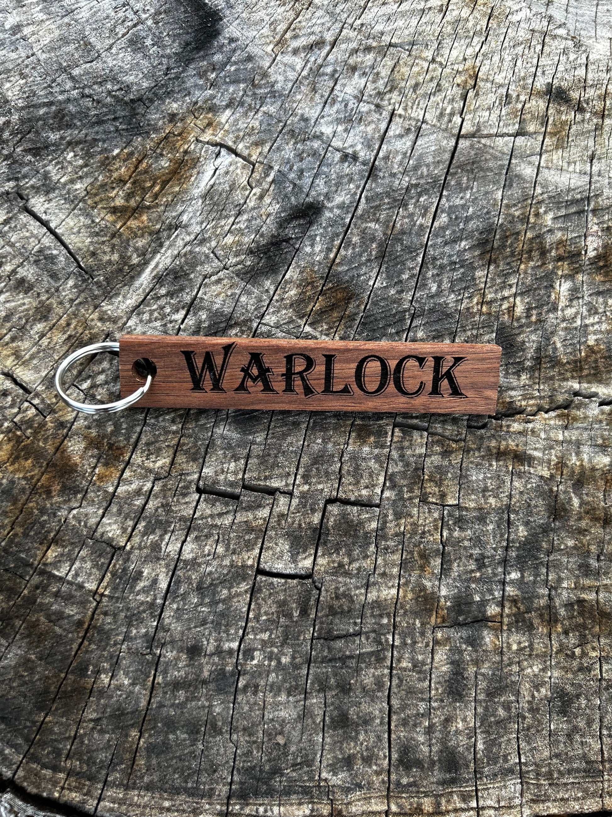 Willow Wooden Keychain with the word "Warlock" and the Oakley Nerd Nook logo pressed into it